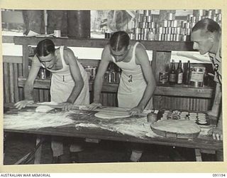 JACQUINOT BAY, NEW BRITAIN. 1945-04-26. PRIVATE B. MCKENZIE (1) AND PRIVATE W. HIBBES (2), ROLLING OUT DOUGH AT A SCHOOL OF COOKING CONDUCTED BY WARRANT OFFICER II GIBBES (3), AT 4 FIELD AMBULANCE