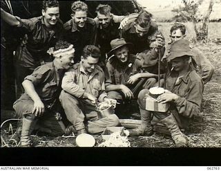 Ramu Valley, New Guinea. 1943-12-25. Personnel of the 2/31st Infantry Battalion sharing their Christmas cakes on Christmas morning in the Kesewai area