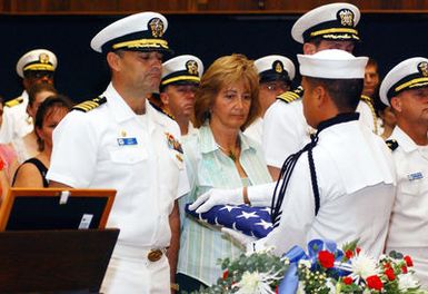 U.S. Navy CAPT. Leo Goff, Commanding Officer, L.Y. Spear Class Submarine Tender USS FRANK CABLE (AS 40), prepares to accept an American flag on behalf of the family of Machinery Repairman Fireman (MRFN) Jack Valentine during a memorial service held in the chapel on Naval Base Guam on Dec. 10, 2006. MRFN Valentine died on Dec. 8 at Brooke Army Medical Center in San Antonio, TX, from injuries sustained during a Dec. 1 boiler explosion aboard the Guam based submarine tender. The flag will be hand delivered to Valentine's family by USN CAPT. Leo Goff, the ship's commanding officer. (U.S. Navy photo by Mass Communication Second Class Stefanie Broughton) (Released)