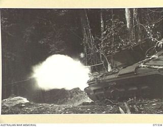 GUSIKA, NEW GUINEA. 1944-03-18. A MATILDA TANK FROM THE 1ST TANK BATTALION FIRING ITS 2 POUNDER GUN DURING MOVEMENT ALONG THE JUNGLE TRACK FROM BONGA TO GUSIKA