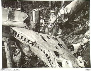 1943-07-09. NEW GUINEA. WAU-MUBO AREA. NEAR THE MUBO TRACK IS THE WRECKAGE OF A TRANSPORT PLANE. THE PLANE CRASHED WHILE TRANSPORTING FOOD AND AMMUNITION TO FORWARD AREAS. SUPPLIES ARE DROPPED TO ..