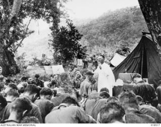 BUT, NEW GUINEA. MAY 1945. FATHER JOHN ALOYSIUS MOGAN OF MELBOURNE, VIC, CELEBRATING MASS FOR 6TH DIVISION TROOPS ON THE EVE OF THE AMPHIBIOUS OPERATION WHICH RESULTED IN THE DEFEAT OF THE JAPANESE ..