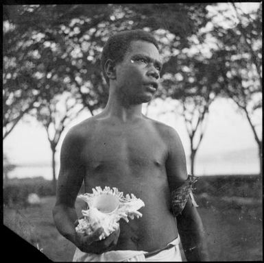 Man holding a murex shell, Rabaul, New Guinea, ca. 1936 / Sarah Chinnery