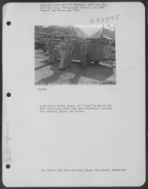 A Red Cross worker passes out "cokes" to men of the 38th Bomb Group after they have completed a mission. Port Moresby, Papua, New Guinea. (U.S. Air Force Number 81073AC)