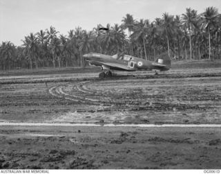 MILNE BAY, PAPUA. C. 1942-09. A KITTYHAWK AIRCRAFT OF NO. 75 SQUADRON RAAF TAXIING ALONG THE MUDDY GURNEY AIRSTRIP