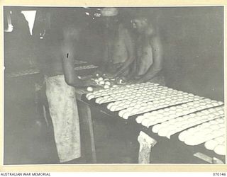 DUMPU, NEW GUINEA. 1944-02-05. NX136150 STAFF SERGEANT A.W. HUEGILL (1) IN CHARGE OF THE 15TH INFANTRY BRIGADE BAKERY, INSTRUCTING COOKS IN MOULDING ROLLS