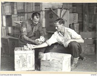 LAE, NEW GUINEA. 1944-08-27. VX1444 SERGEANT D.V. NOONAN (1) AND SX31108 CORPORAL F.S. PATTON (2) PACKING COMFORTS FOR THE TROOPS AT THE AUSTRALIAN COMFORTS FUND HEADQUARTERS