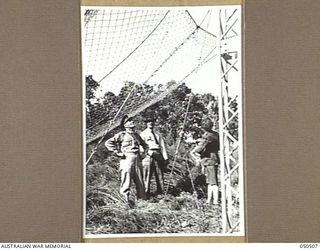 LANGWARRIN, AUSTRALIA. 1943-04. ERECTION OF A WIRE MESH NET FOR AN EXPERIMENT IN SUPPLY-DROPPING FROM AIRCRAFT, ON TO A PREPARED CATCHMENT AREA, UNDER CONDITIONS SIMILAR TO THOSE ENCOUNTERED IN NEW ..