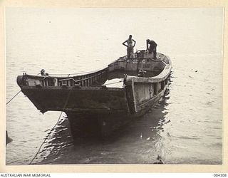 CUTARP PLANTATION, JACQUINOT BAY, NEW BRITAIN. 1944-12-15. 14/32 INFANTRY BATTALION OFFICERS INSPECTING A JAPANESE BARGE CAPTURED IN RONDAHL HARBOUR