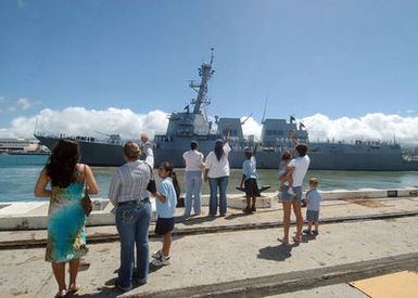 Family members and friends waves good-bye to loved ones onboard the US Navy (USN) Arleigh Burke Class Guided Missile Destroyer, USS CHAFEE (DDG 90) as she is underway leaving Pearl Harbor, Hawaii (HI), on her maiden deployment with the USN Nimitz Class Aircraft Carrier, USS NIMITZ (CVN 68) Carrier Strike Group (CSG) in support of the Global War on Terrorism (GWOT)