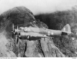 NEW GUINEA. C. 1942. BEAUFIGHTER AIRCRAFT OF NO. 30 SQUADRON RAAF (PILOT FLYING OFFICER R. J. BRAZENOR; OBSERVER SERGEANT F. B. ANDERSON) IN FLIGHT CLOSE TO A ROCKY OUTCROP IN A VALLEY IN THE OWEN ..