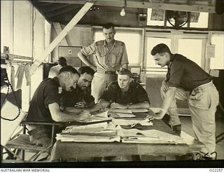 TOROKINA, BOUGAINVILLE ISLAND, SOLOMON ISLANDS. 1945-02-18. MAJOR D. G. DANIELL, AIR LIAISON OFFICER OF NO. 5 (BOOMERANG) SQUADRON RAAF AT PIVA AIRFIELD, INTERROGATES PILOTS AFTER THEIR RETURN FROM ..