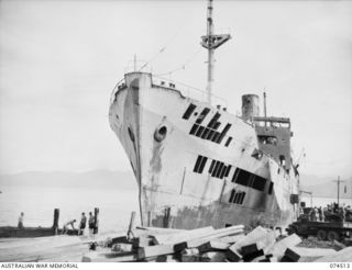 LAE, NEW GUINEA. 1944-07-05. A BLITZED JAPANESE MERCHANT VESSEL, THE MYOKO MARU, WHICH WAS RUN ASHORE BY THE CAPTAIN TO PREVENT ITS FOUNDERING. SOME OF THE VESSELS HULL PLATES HAVE ALREADY BEEN ..