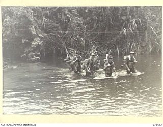 Forward troops of the 35th Infantry Battalion cross the river during their drive up the coast to Wewak. Identified personnel are: Corporal Farmer (left); Lance Corporal (LCpl) G Druce (at rear ..