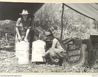 JACQUINOT BAY, NEW BRITAIN. 1944-11-26. CAPTAIN C. THOMPSON, SALVATION ARMY REPRESENTATIVE (1) AND S51573 PRIVATE K. STOTT (2) SETTING UP THE SALVATION ARMY RED SHIELD HUT FOR THE TROOPS OF THE ..