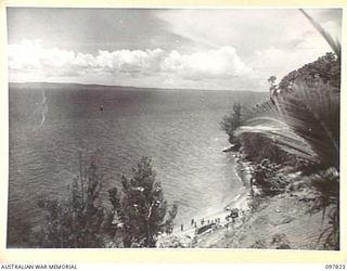 KANGU HILL, BOUGAINVILLE. 1945-10-05. KANGU HILL LOOKING ACROSS BOUGAINVILLE STRAIT TO SHORTLAND ISLAND. NATIVES CAN BE SEEN UNLOADING RATIONS AT AGUA SOUTH OF BOUGAINVILLE