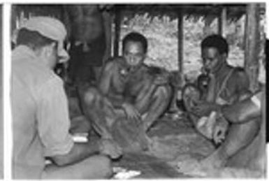 Men playing cards; in middle is Winitaemu