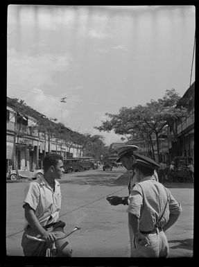 Street scene with police officer talking to man on bicycle, Papeete, Tahiti