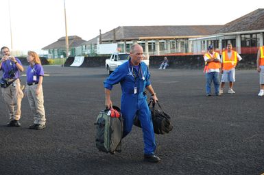 Earthquake ^ Tsunami - Pago Pago, American Samoa, October 5, 2009 -- A member of a Disaster Medical Assistance Team (DMAT) rushes supplies onto an awaiting Coast Guard plane that will evacuate an infant to Hawaii. DMATs are part of the U. S. Department of Health and Human Services' National Disaster Medical System which supports hospitals and other medical and public health needs of communities during disasters such as the earthquake and tsunami disaster in American Samoa. FEMA/Casey Deshong