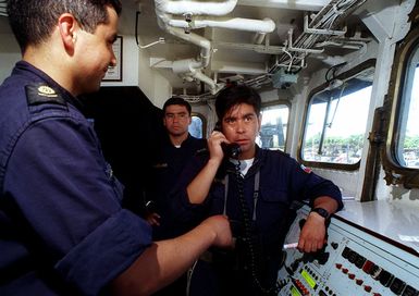 Aboard the bridge of the Chilean frigate CNS CONDELL (FFH 6), PETTY Officer Bienvento (right) communicates with engine room personnel during steam plant evolutions prior to leaving Bravo Pier during the exercise RIMPAC 98