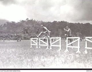 TOROKINA, BOUGAINVILLE, 1945-12-05. PRIVATE M. C. RODGER, 8TH INFANTRY BATTALION, WINNING THE 120 YARDS HURDLE RACE DURING THE 3 DIVISION AMENITIES CARNIVAL HELD AT GLOUCESTER OVAL