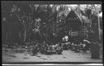 Hookworm lecture in front of yam houses, Trobriand Islands