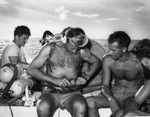 Divers, including Walter Munk (securing belt) and Willard Bascom (to right of Munk), work from a motor launch at Alexa Bank, Samoa