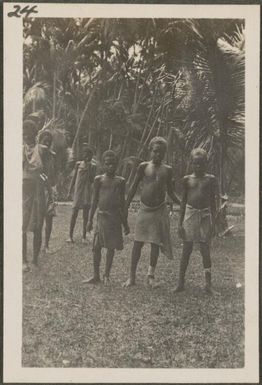 Tolai boys, boy in centre is wearing a crucifix, New Britain Island, Papua New Guinea, approximately 1916