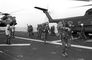 Marines exit from a CH-53 Sea Stallion helicopter aboard the amphibious assault ship USS GUAM (LPH 9), as the 22nd Marine Amphibious Unit redeploys from Beirut at the conclusion of a multinational peacekeeping operation. Another CH-53 is visible in the background