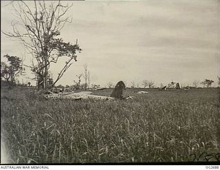 BUT AREA, DAGUA, NORTH EAST NEW GUINEA. C. 1945-04. A CORNER OF THE DAGUA AIRFIELD, NEAR WEWAK, AFTER IT HAD BEEN CAPTURED BY THE AUSTRALIANS ON 1945-03-21. IN THE FOREGROUND IS A JAPANESE BROKEN ..