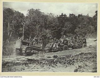 KARAWOP KOFI AREA, NEW GUINEA. 1945-04-21. 2/2 FIELD REGIMENT, ROYAL AUSTRALIAN ARMY, TROOPS ON THEIR 25-POUNDERS BEING TOWED BY A TRACTOR AS THEY MOVE FOREWARD TO KARAWOP FROM DAGUA OVER ROUGH, ..