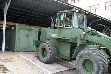 US Marine Corps (USMC) Sergeant (SGT) Wills, assigned to Combat Service Support Group 3 (CSSG-3), Marine Forces Pacific (MARFORPAC) uses a Rough Terrain Forklift to tow a Combat Camera and Printing (CC&P) portable transport van to a staging area at Camp H.M. Smith, Hawaii (HI), as the Unit prepares for deployment to Iraq, in support of Operation IRAQI FREEDOM