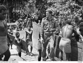 Troops of B Company, 1st New Guinea Infantry Battalion loading stores and supplies on to a landing craft mechanised for transport to Sampun with the help of some natives. Identified personnel are: ..