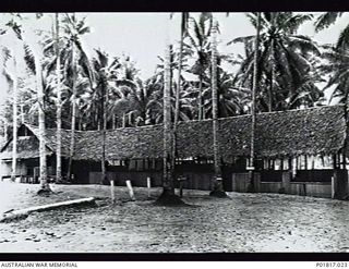 Milne Bay, Papua, 1944-03-18. Front view of the main Administration Hut at the base occupied by the Headquarters (HQ) of RAAF Northern Command. The sign on the tree trunk at right reads: "Central ..