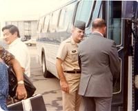 Pilot talking to a man by a bus