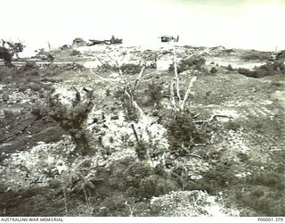 REMAINS OF A JAPANESE CAMP AND HALF-TRACKED VEHICLE ON THE COASTAL ROAD, NUSA PARADE. (RNZAF OFFICIAL PHOTOGRAPH.)