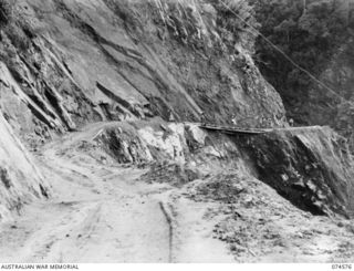NEW GUINEA. 1944-07-09. THE STEELE FALLS SECTION OF THE NEW WAU-BULLDOG ROAD UNDER CONSTRUCTION WHERE IT RUNS ALONG A CLIFF FACE OF STEEPLY INCLINED ROCK STRATA