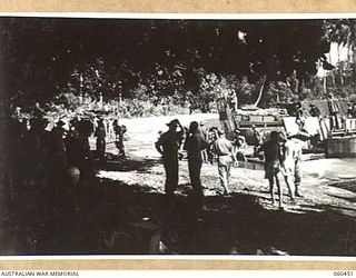 FINSCHHAFEN AREA, NEW GUINEA. 1943-11-09. UNLOADING SUPPLIES AND TROOPS AT KEDAM BEACH, THE MAIN SUPPLY POINT FOR THE 870TH UNITED STATES ENGINEER AVIATION BATTALION. THIS UNIT IS PREPARING THE ..