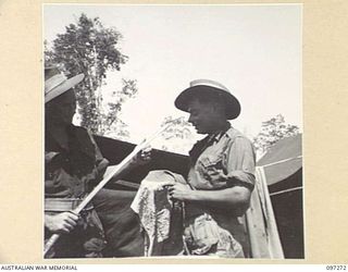 CAPE WOM, NEW GUINEA. 1945-09-29. LANCE CORPORAL R.C. COSTELLO (1) AND LANCE CORPORAL L.W. CREER (2), MEMBERS OF 2/3 INFANTRY BATTALION, DISPLAYING A CAPTURED JAPANESE SWORD AND FLAG