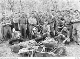 1943-09-15. PARATROOPS LAND AT NADZAB. AUSTRALIAN GUNNERS WITH THEIR WEAPONS DISMANTLED, AND THE PARTS ATTACHED TO PARACHUTES, WAIT FOR THE ORDER TO DON THEIR OWN PARACHUTES AND EQUIPMENT PRIOR TO ..