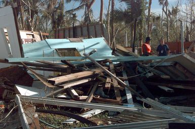 Timara Graves, Community Relations Field Officer for the Federal Emergency Management Agency, consults with Joaquin Benavente about the loss of his family's home after Typhoon Paka swept through Guam