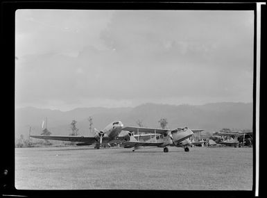 Qantas Empire Airways, lighted-up aeroplane on the runway [at night?], Bulolo Airfield, Morobe, Papua New Guinea