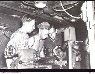 TOROKINA, BOUGAINVILLE, 1945-12-03. CORPORAL A. HOFF (3) INSTRUCTING PRIVATE J. D. HINE (1) AND SIGNALMAN W. J. WOOD (2) IN THE USE OF A LATHE AT THE TOROKINA REHABILITATION TRAINING CENTRE