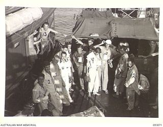 LALUM, BOUGAINVILLE, 1945-06-12. PATIENTS FROM 19 FIELD AMBULANCE MAIN DRESSING STATION WAITING TO BE TRANSFERRED FROM A BARGE TO THE HOSPITAL SHIP STRADBROKE. (FOR IDENTIFICATION OF 10 NAMED ..