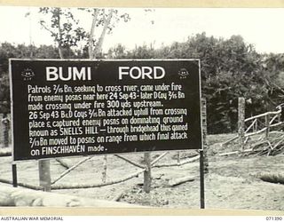 BUMI FORD, FINSCHHAFEN AREA, NEW GUINEA, 1944-03-20. ONE OF MANY BATTLE SIGNS IN THE FINSCHHAFEN AREA, THIS SIGN RECORDS ACTIVITIES OF THE 2/13TH AND 2/15TH INFANTRY BATTALIONS IN THE AREA OF BUMI ..