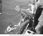 Lieutenant (jg) Burris D. LaMar emerging from the water as Dr. Arthur D. Welander is preparing to dive, Bikini Atoll, summer 1947