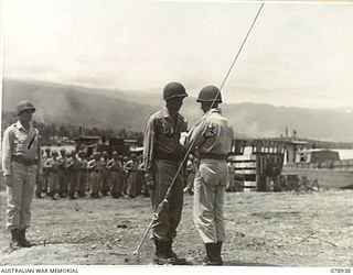 JACQUINOT BAY, NEW BRITAIN. 1945-02-07. T4 I. JUDGE, 594TH ENGINEER BOAT AND SHORE REGIMENT, B COMPANY, UNITED STATES ARMY, BEING INVESTED WITH THE UNITED STATES SOLDIERS MEDAL BY HIS COMMANDING ..