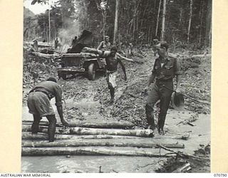 GABENSIS, NEW GUINEA, 1944-03-02. NG2413 WARRANT OFFICER II, TOM ZOFFMAN, AUSTRALIAN NEW GUINEA ADMINISTRATIVE UNIT ( ), SUPERVISING NATIVE WORKERS ON THE WAU - LAE ROAD