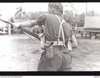 RABAUL, NEW BRITAIN, 1945-12-06. THE CUP DISCHARGER BAG ON A SOLDIER'S BELT. IT IS THE OPENED POUCH NEAREST THE CAMERA AND IS USED TO HOLD THE GRENADE DISCHARGER CUP ATTACHED TO THE BARREL OF THE ..