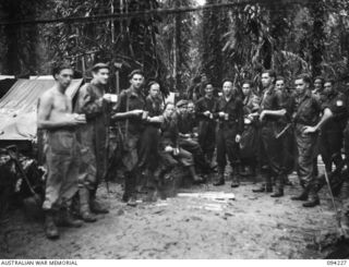 SOUTH BOUGAINVILLE, 1945-07-20. TROOPS OF 58/59 INFANTRY BATTALION, 15 INFANTRY BRIGADE, WHO HAVE JUST RETURNED FROM A JUNGLE PATROL THROUGH HEAVY RAINFALL, WELCOME A BREW AT THE YMCA TEA STALL ON ..